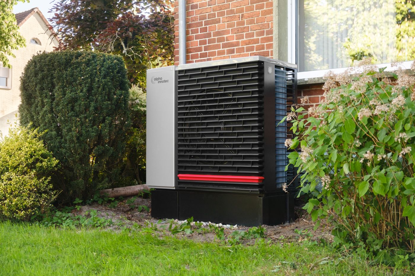 Wärmepumpe im Garten eines Bestandsgebäudes