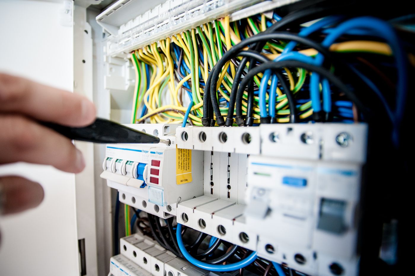 Elektriker arbeitet an einem geöffneten Sicherungskasten