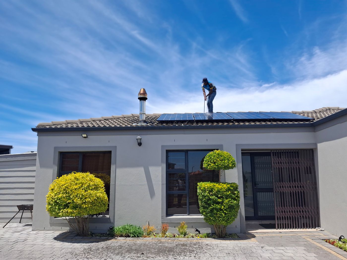 Handwerker installiert Photovoltaikmodule auf einem Wohnhausdach